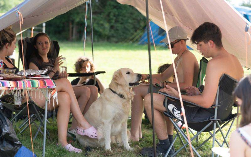 Family sitting with dog in tent
