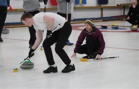 Group of people curling with 1 person brushing the ice
