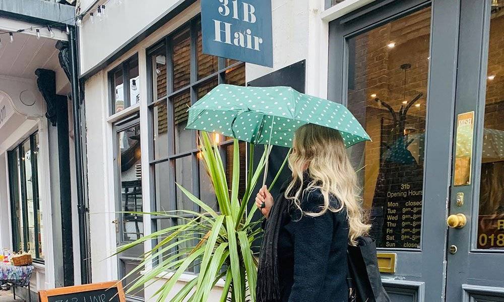 31b Hair Salon exterior 31b Hair Salon - female leaving the salon with an umbrella