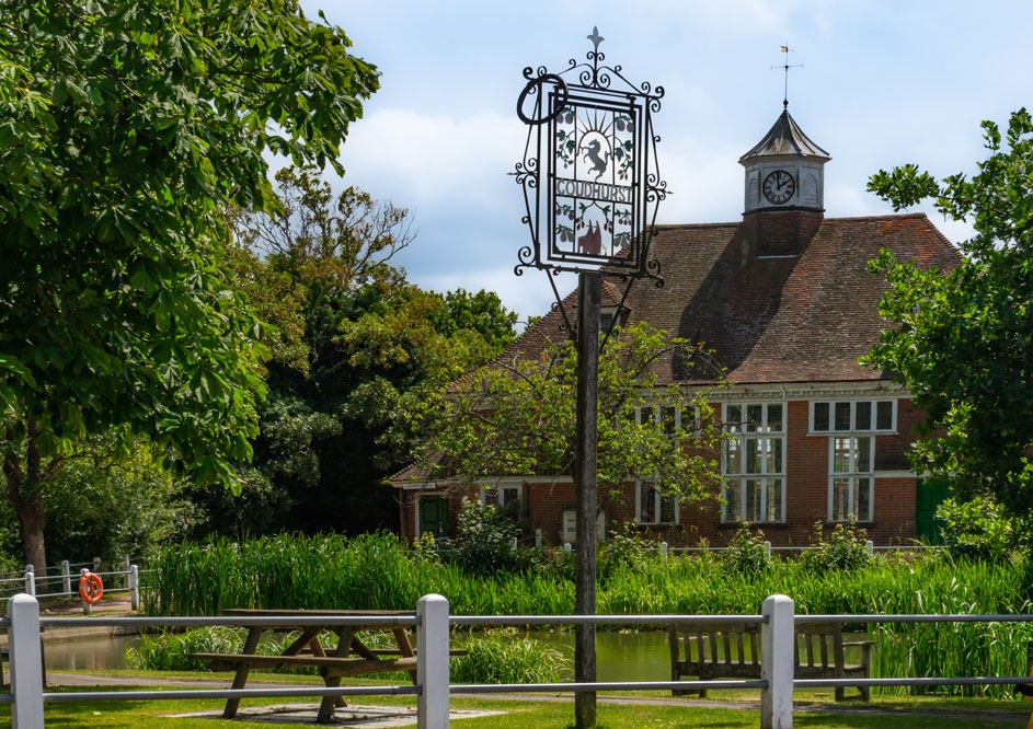 Goudhurst Pond area with benches and village sign