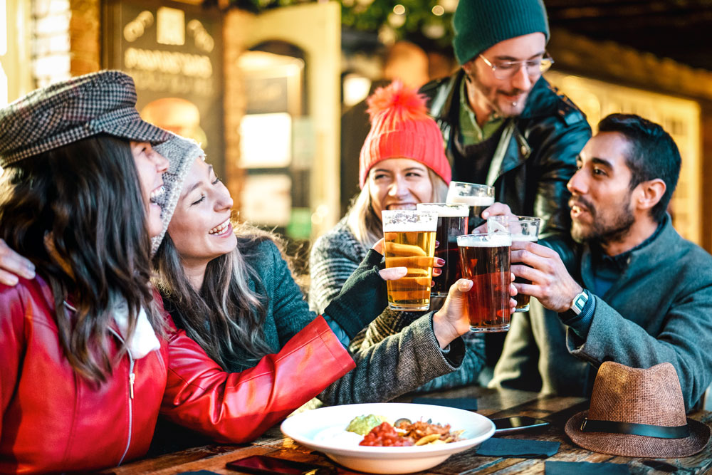 Group of males and females eating in a pub