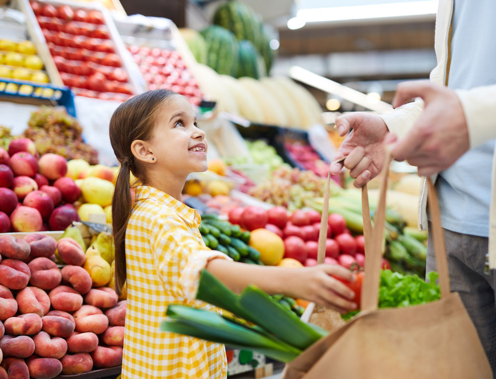 A girl buying some vegetables at a market A girl buying some vegetables at a market