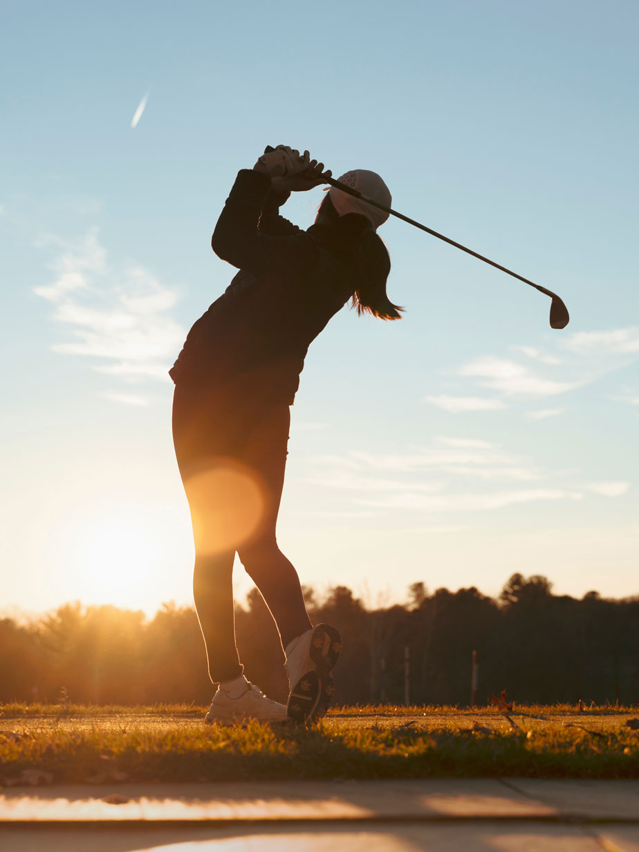 Lady playing golf at sunset Lady playing golf at sunset