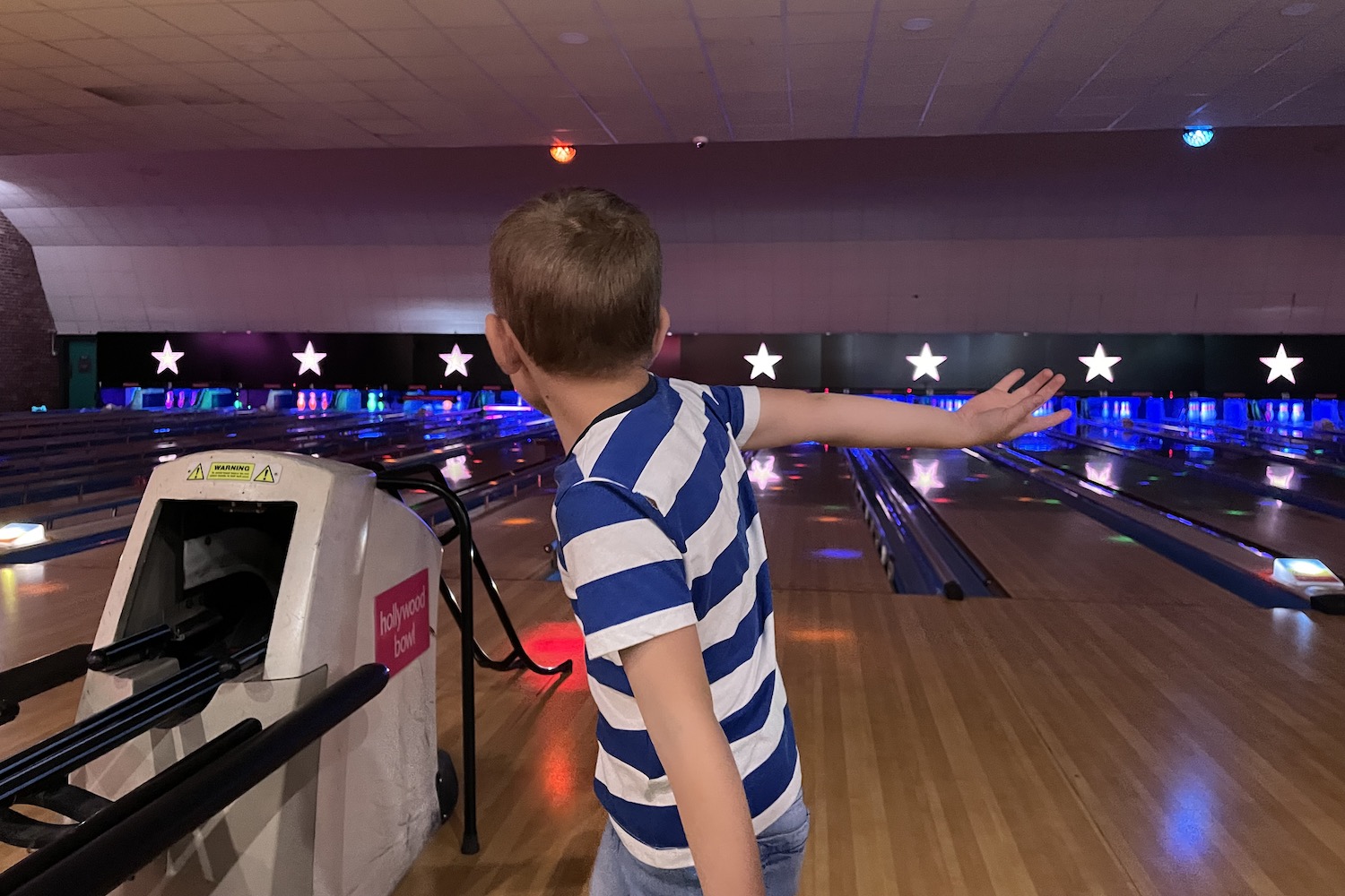 Hollywood Bowl a young boy bowling a ball in a bowling alley