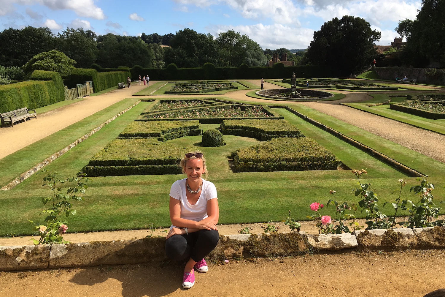 A woman sat on a wall within Penshurst Place & Gardens