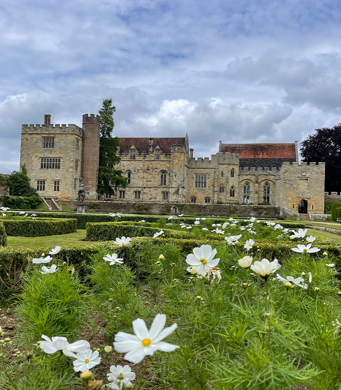 Penshurst-Place-Summer white flowers in the foreground with a medieval castle in the background on a summer day