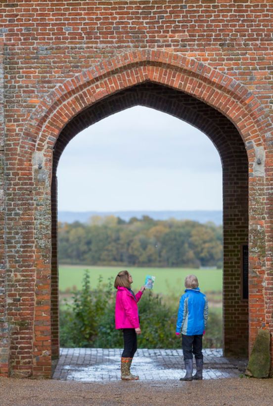 Sissinghurst Castle _Explore Kent two walkers under an arch at Sissinghurst Castle