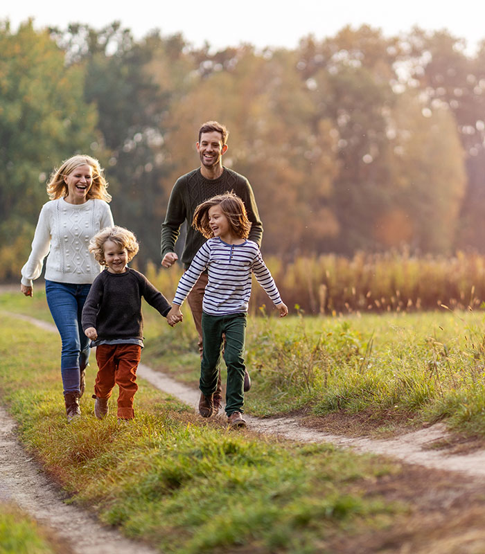 A family walking in the countryside in the sunrays