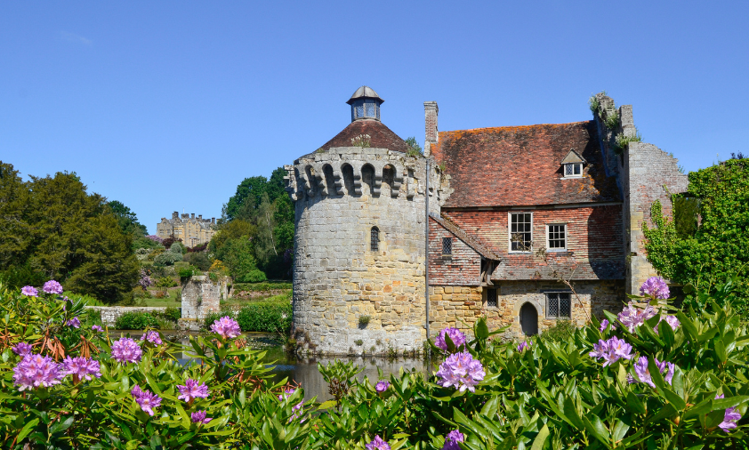 Scotney old castle Medieval castle on a lake surrounded by flowers