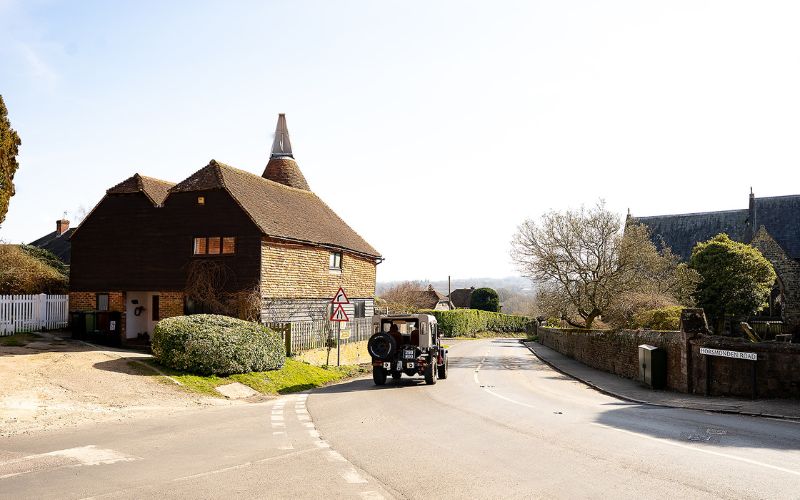 Old car driving though village
