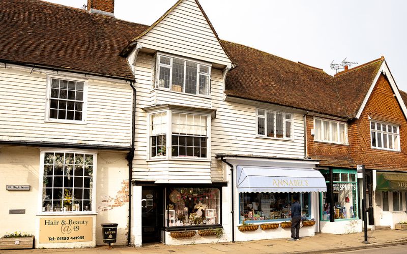 Small shop at the bottom of a white boarded house