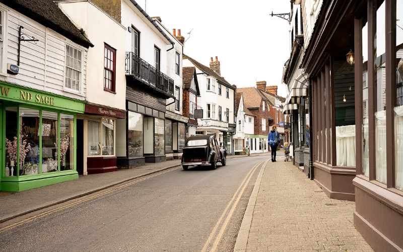 Classic car driving down narrow street