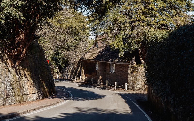 Winding road with high wall on left side