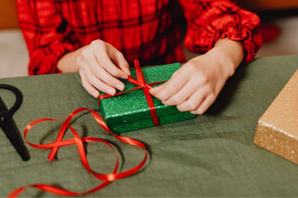 Person tying a bow on a present
